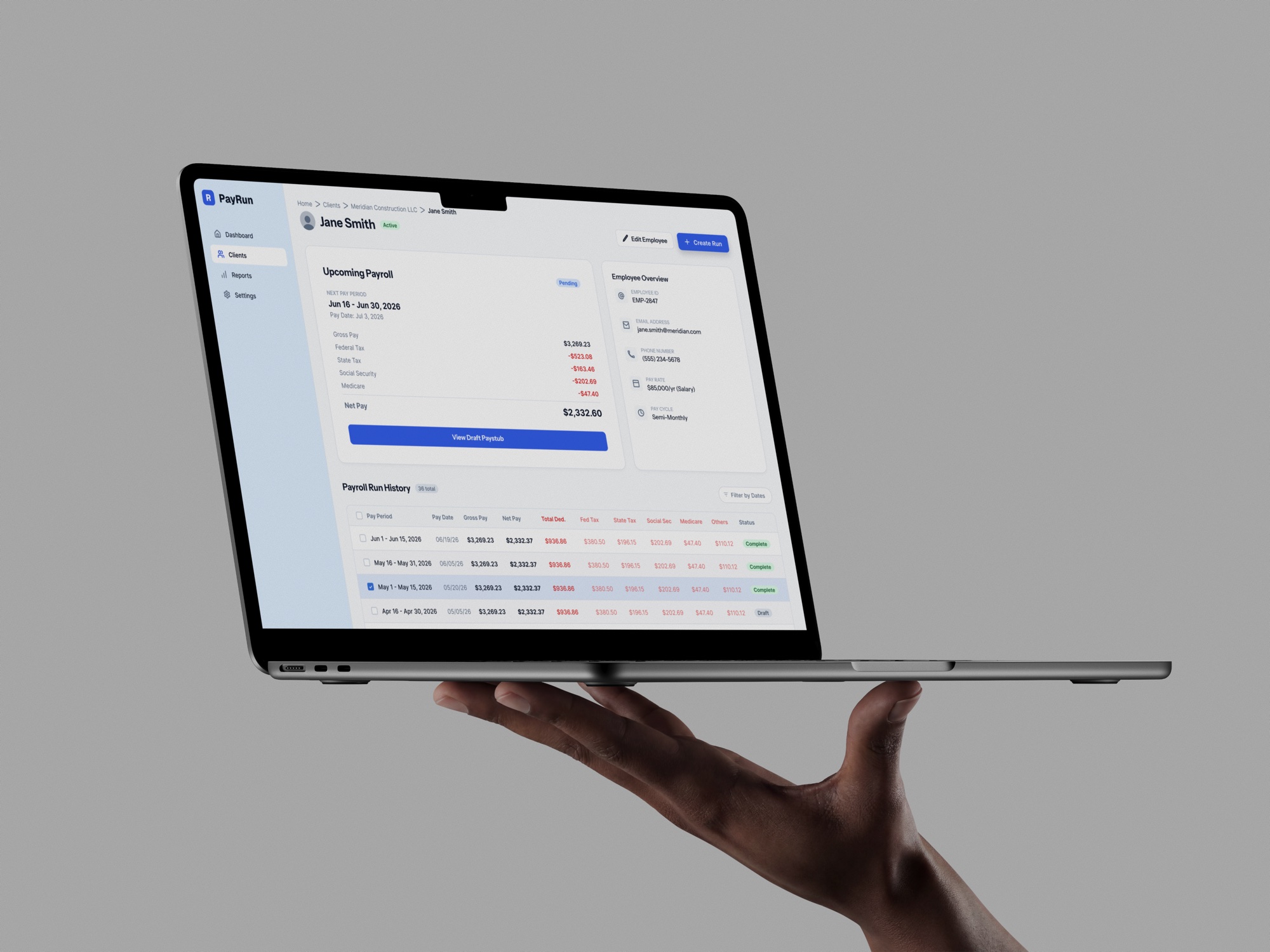PayRun employee page on a laptop held in one hand: upcoming payroll preview and run history